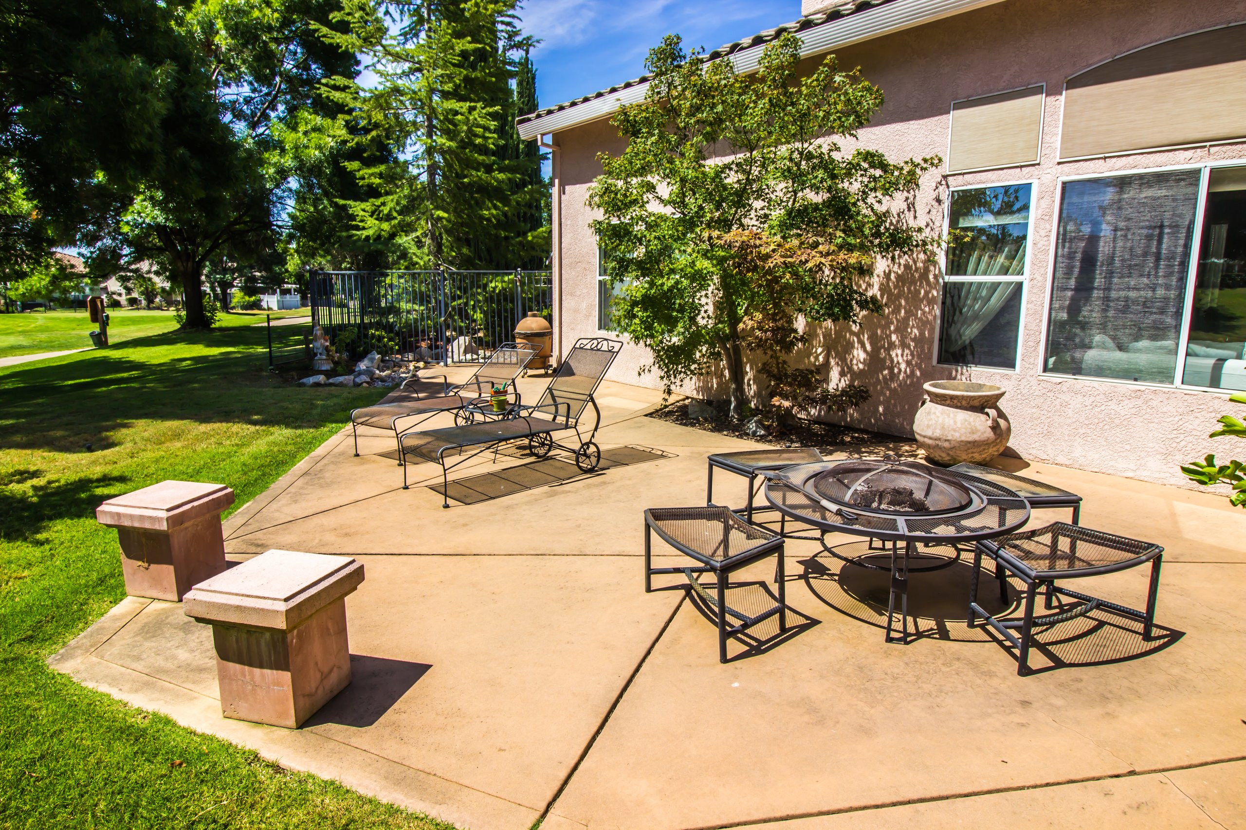Beautiful outdoor patio with wrought iron lounge chairs and fire pit