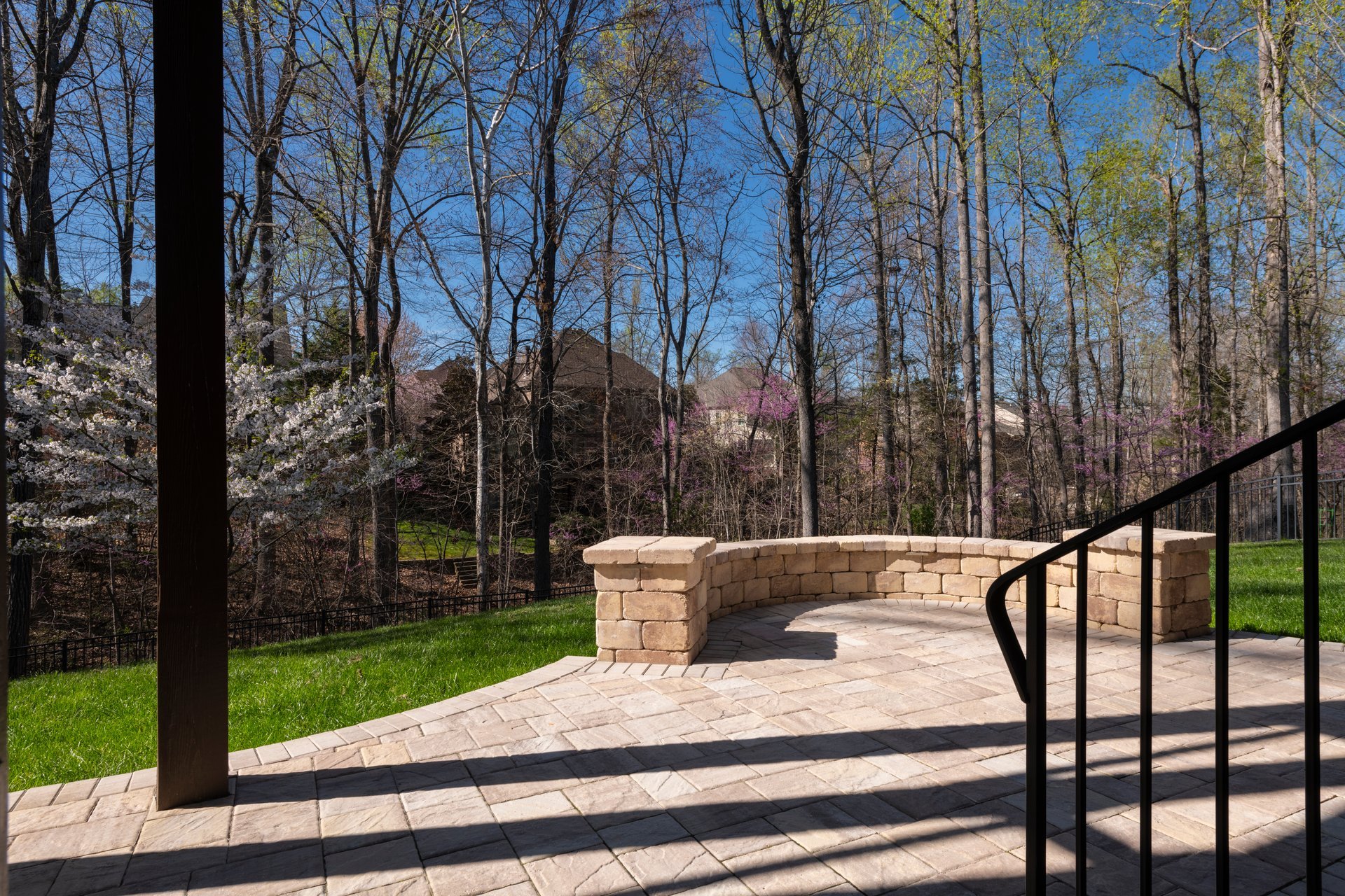 Backyard patio with stone wall and blooming cherry tree