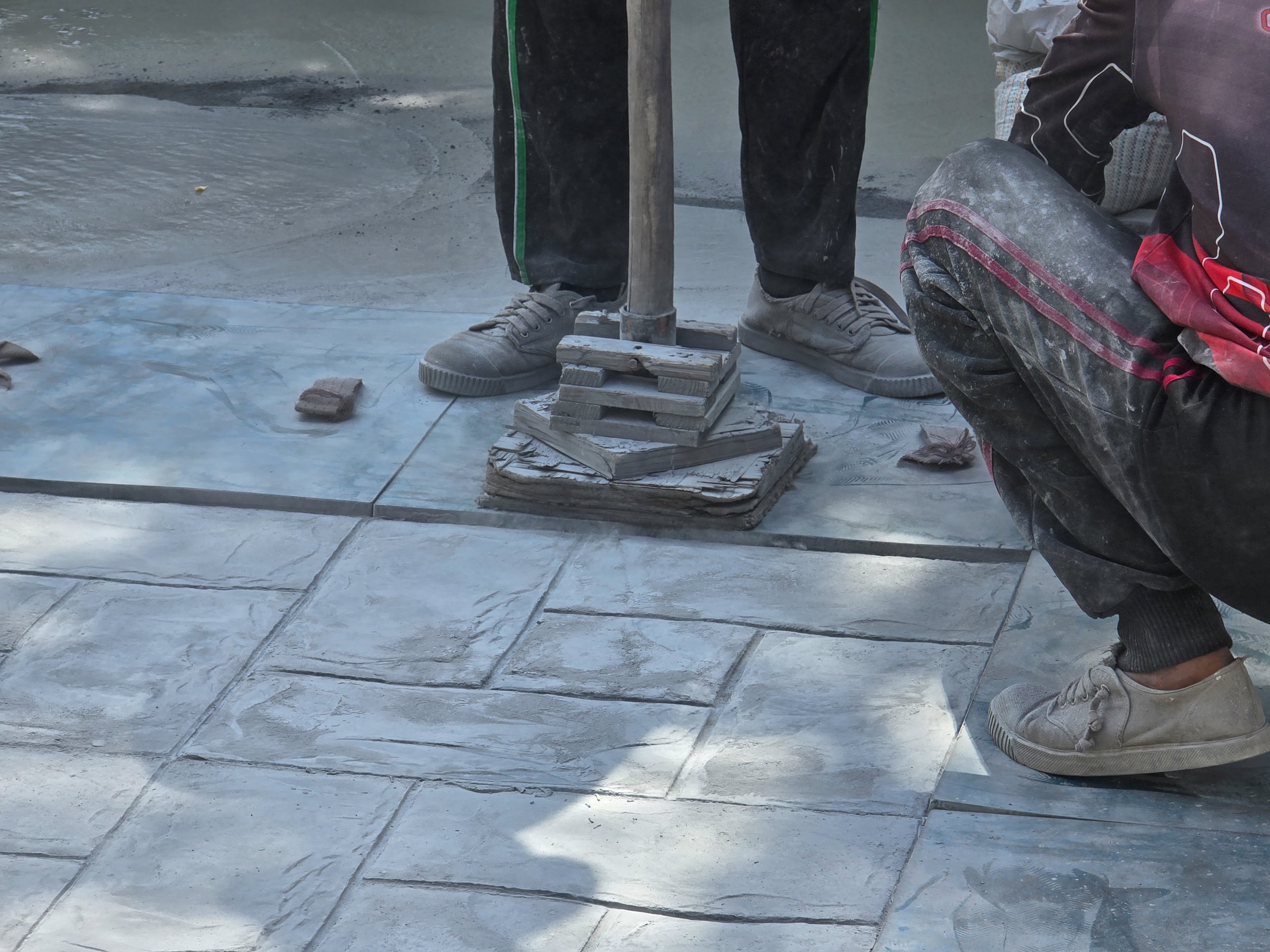 Skilled artisans working on stamped concrete surface
