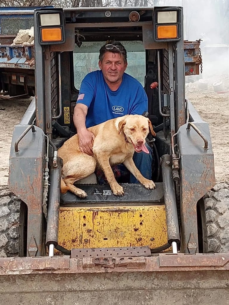 Ken Quindel Jr. with his dog in front of equipment