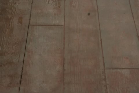 Close-up of wooden flooring with a staggered plank pattern in light brown tones
