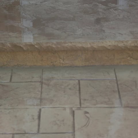 Close-up of tiled floor during construction showing grout lines and unfinished surface with visible seams